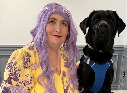 Kassandra sits with black Lab guide dog Sean for their team portrait.