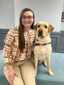 Aliceson and yellow guide dog Gait sit close together for their team portrait