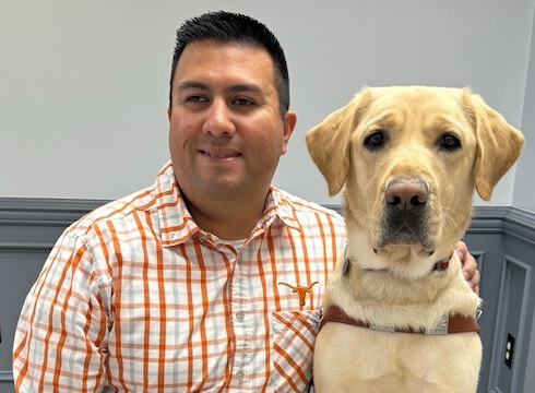 Drew and yellow Lab guide dog Russell sit for their team portrait