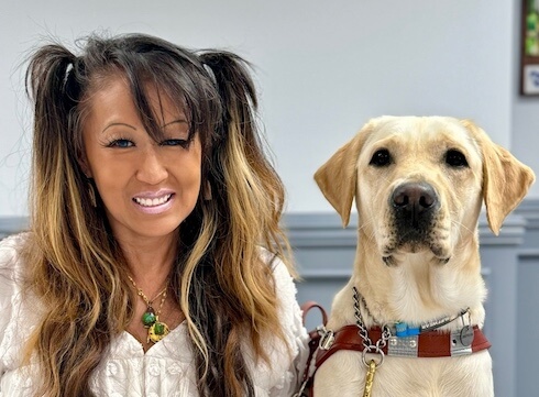 Liz and yellow Lab guide dog Layla sit for their team portrait