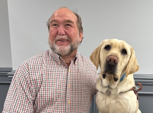 Charles and yellow Lab guide dog Nitro sit side by side for their team portrait