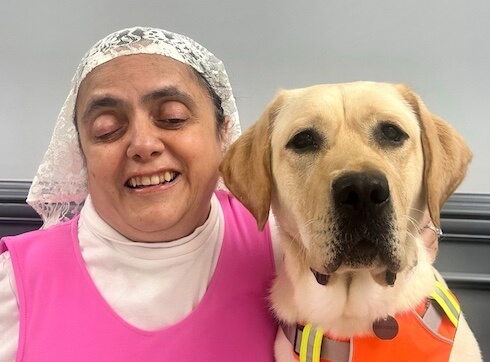 Ramsina and yellow Lab guide dog Arizona sit side by side for their team portrait