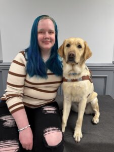 Jamie Leigh and yellow Lab guide dog Louisa sit side by side for team portrait