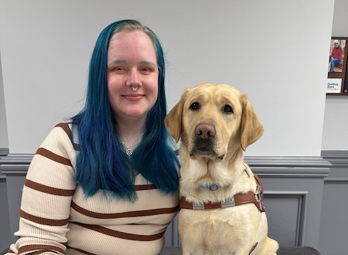 Jamie Leigh and yellow Lab guide dog Louisa sit side by side for team portrait