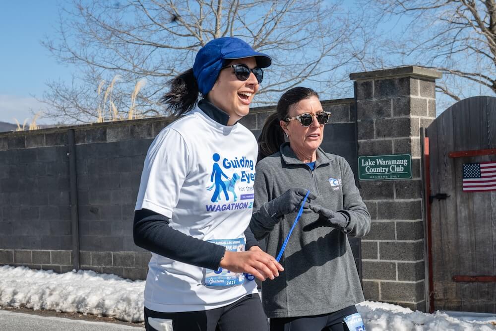 Graduate and Director of Donor Relations, Rebekah, runs with human guide Elena, Chief Development Officer